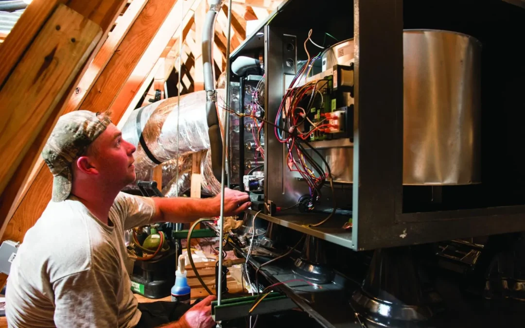 Technician working on an HVAC unit in an attic space.